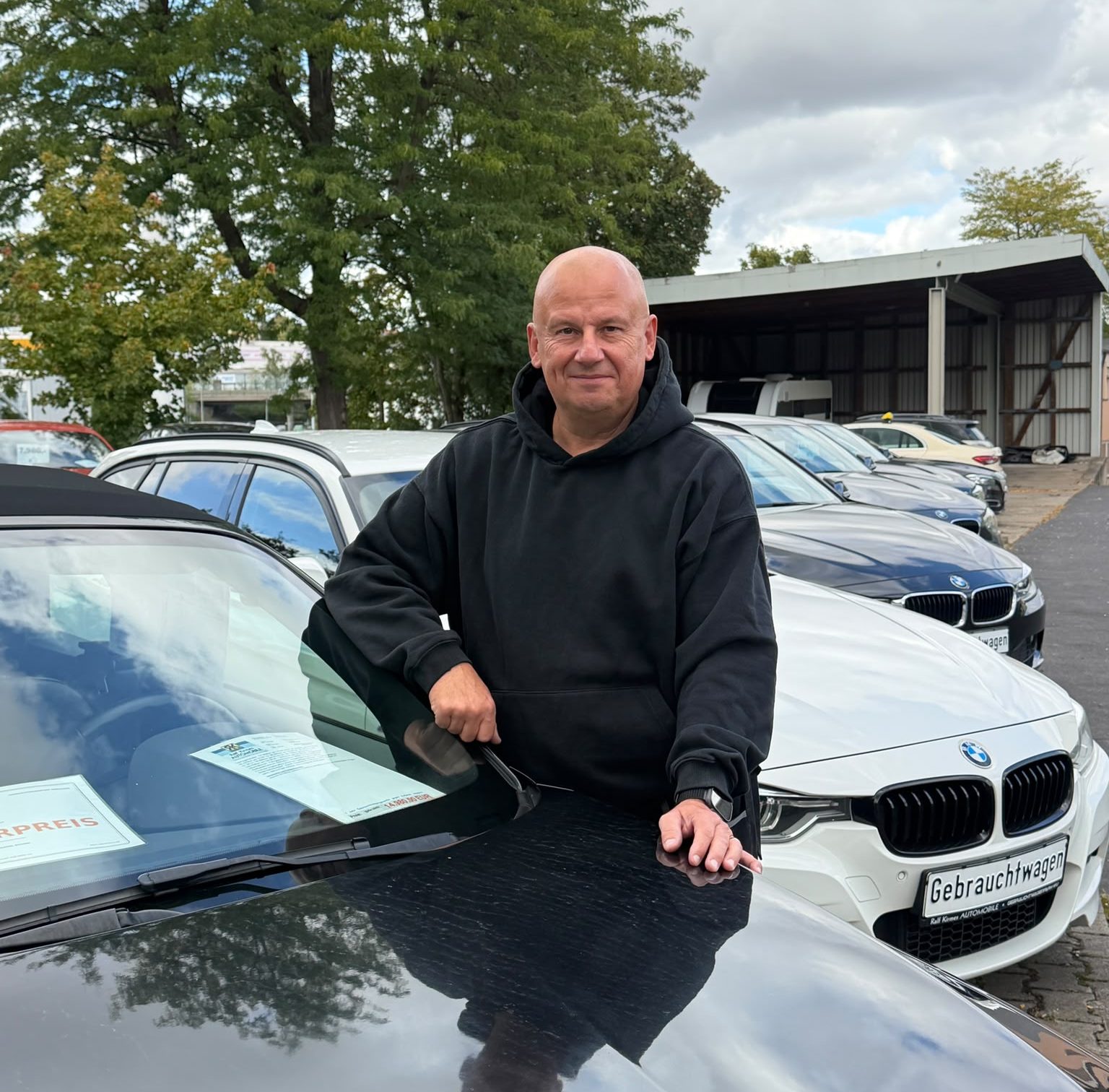 Ralf Kirmes steht auf seinem Hof im Gebrauchtwagenpark Würzburg vor seinen gebrauchten Autos im Verkauf